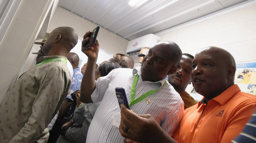 African nations' delegations members taking cell phone photos of the milking system