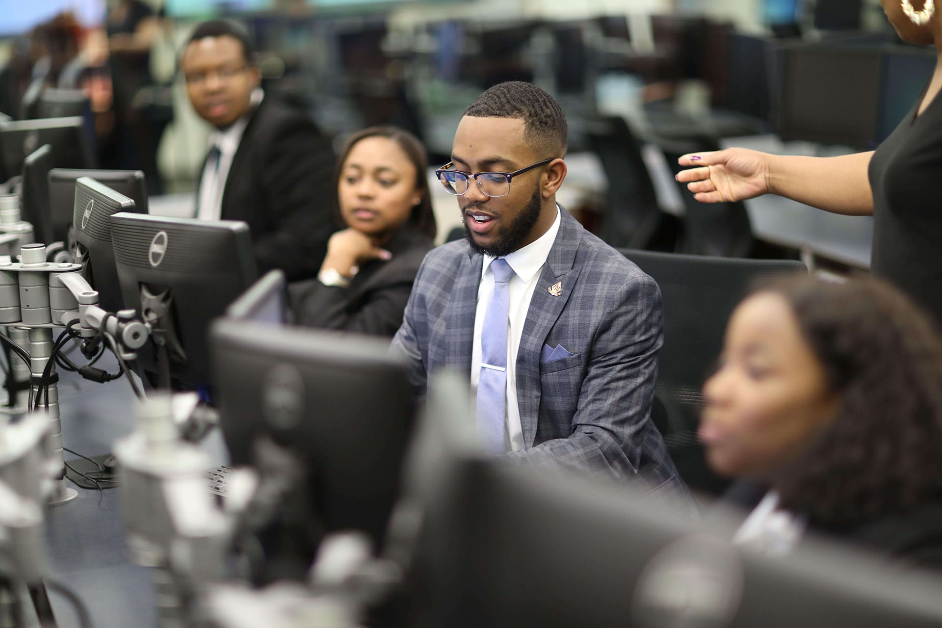 students in professional attire sitting in front of a computer monitor